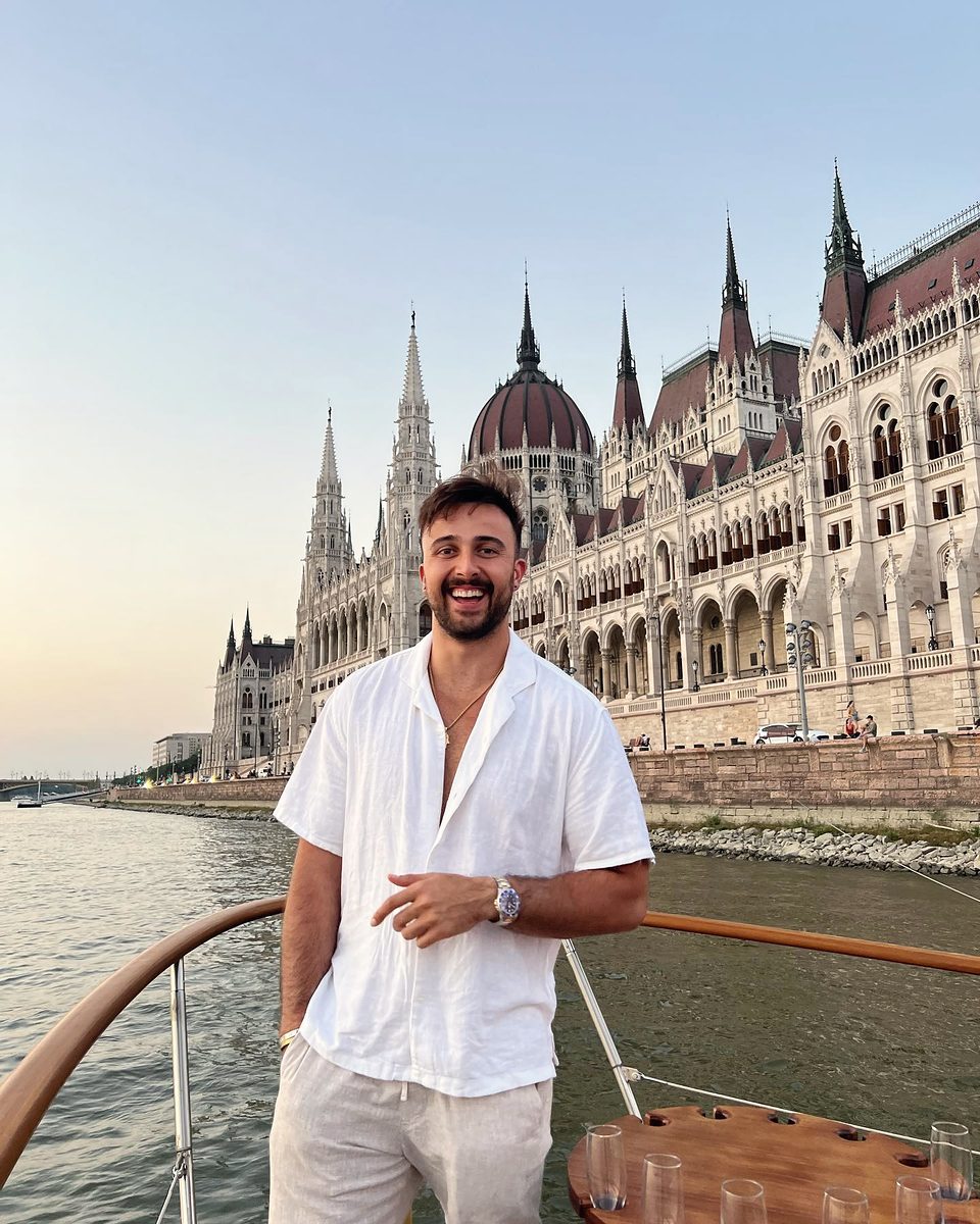 Marczell Klein on a boat on the Danube in Budapest, the Parliament building behind him.