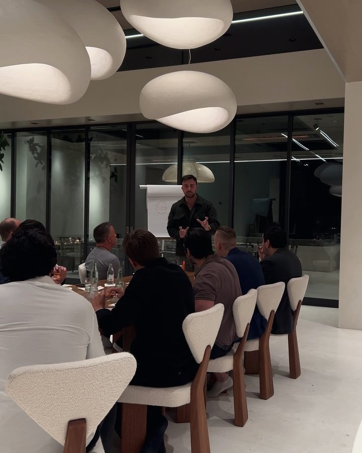Marczell Klein speaking to members around a long dinner table.