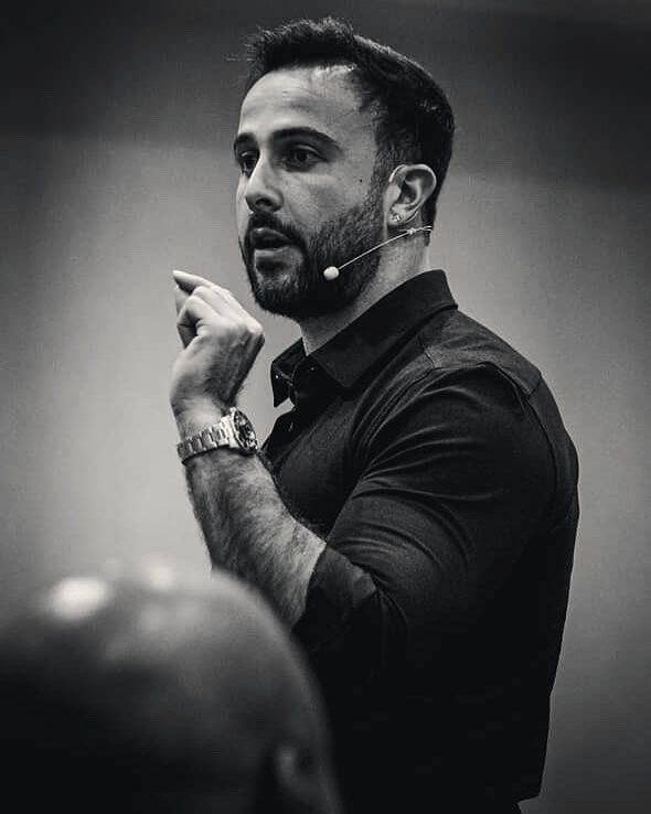 Black-and-white photo of Marczell Klein on stage, mid-gesture.