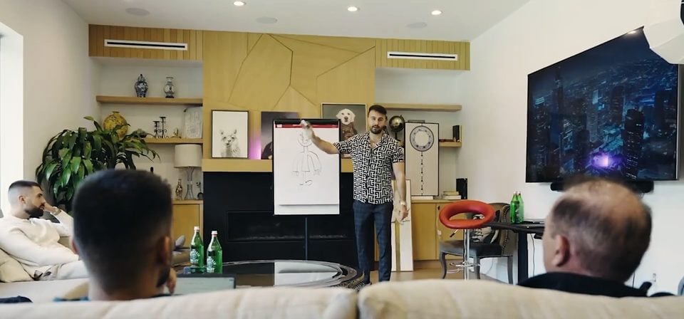 Marczell Klein at a flipchart in a living room, coaching a small group seated on the sofa.