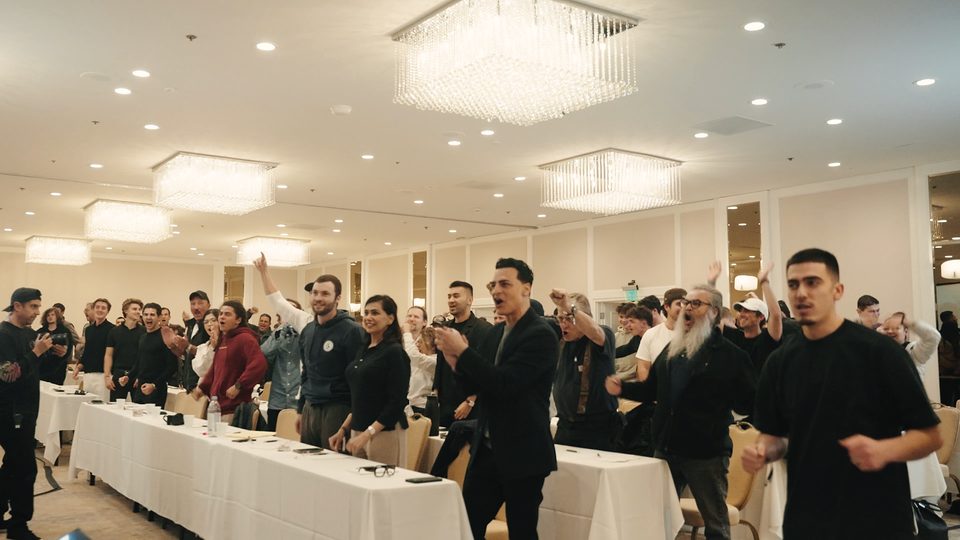 A ballroom audience on its feet, cheering, at one of Marczell Klein's live events.