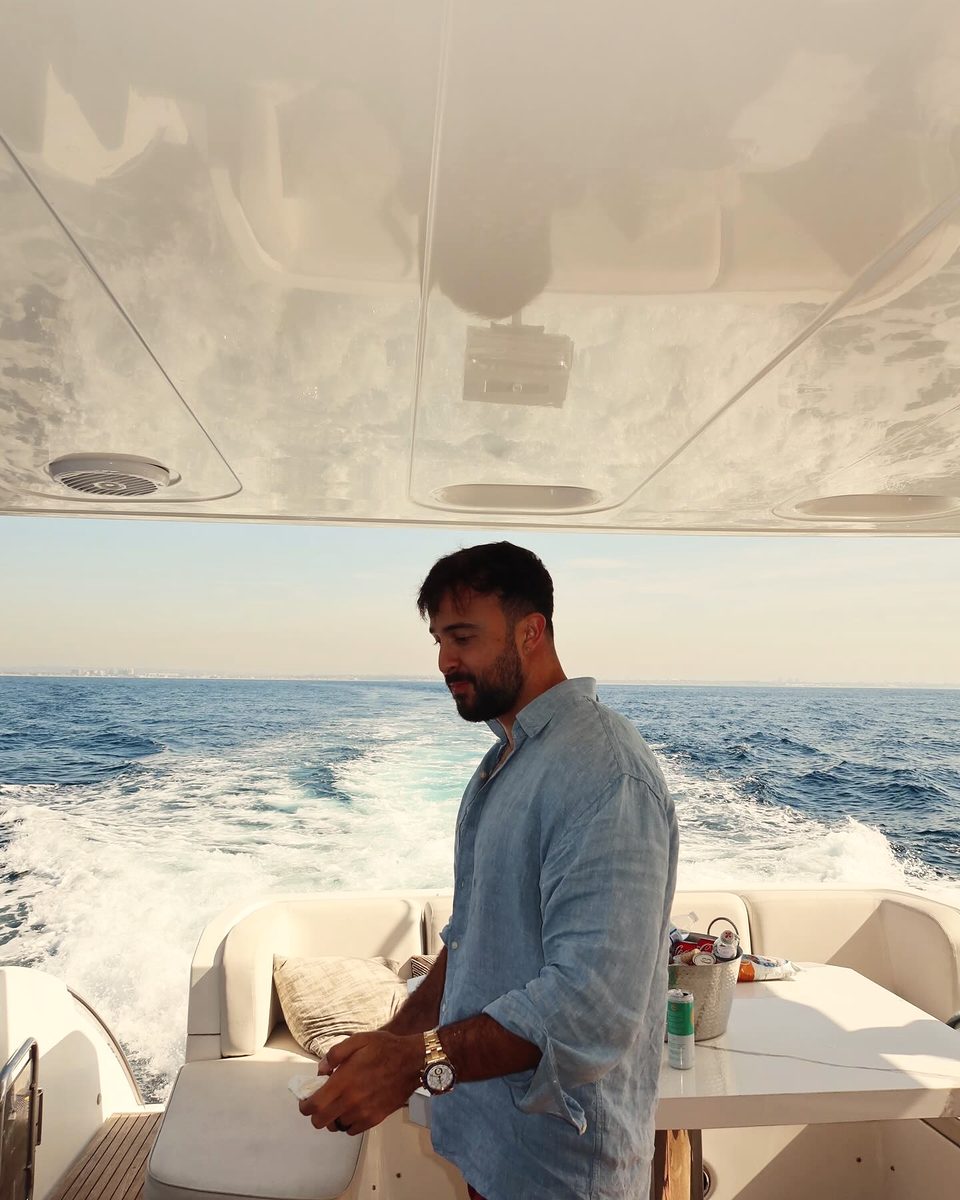 Marczell Klein on the deck of a moving yacht, the wake trailing behind him.