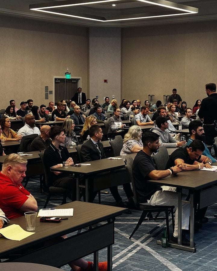 Attendees working at long tables during a seminar.