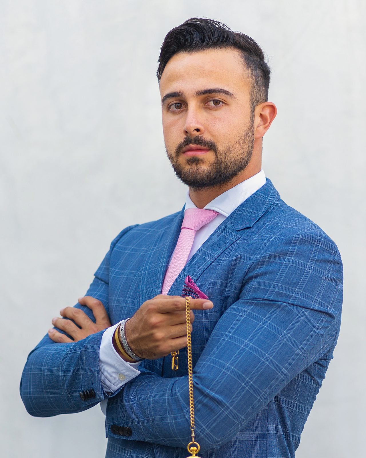 Marczell Klein in a blue checked suit, holding a pocket watch on its chain.