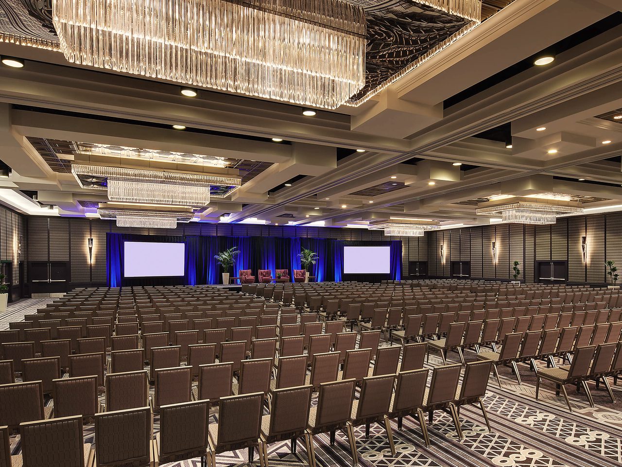 The Los Angeles hotel ballroom, set with rows of chairs facing the stage before the doors open.
